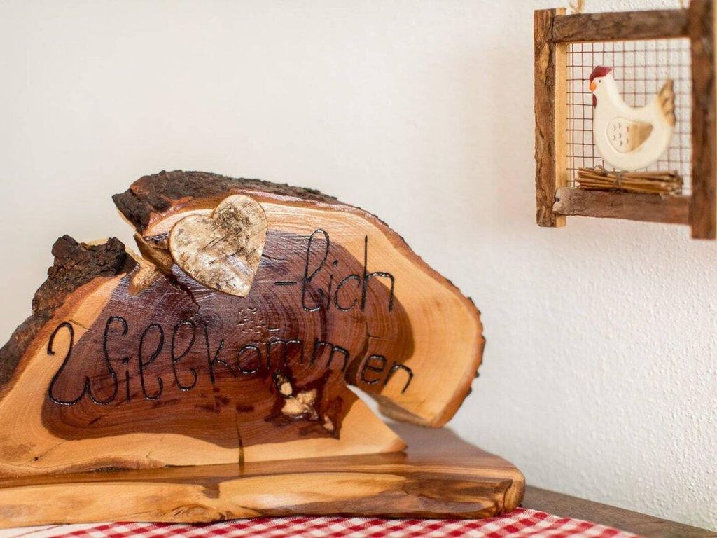Eine HolzSchnitzerei mit der Aufschrift 'Zollverein' und 'Zollverein', platziert auf einem Tisch mit kariertem Tischtuch.