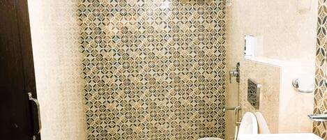Un baño con inodoro, lavamanos y cabina de ducha.