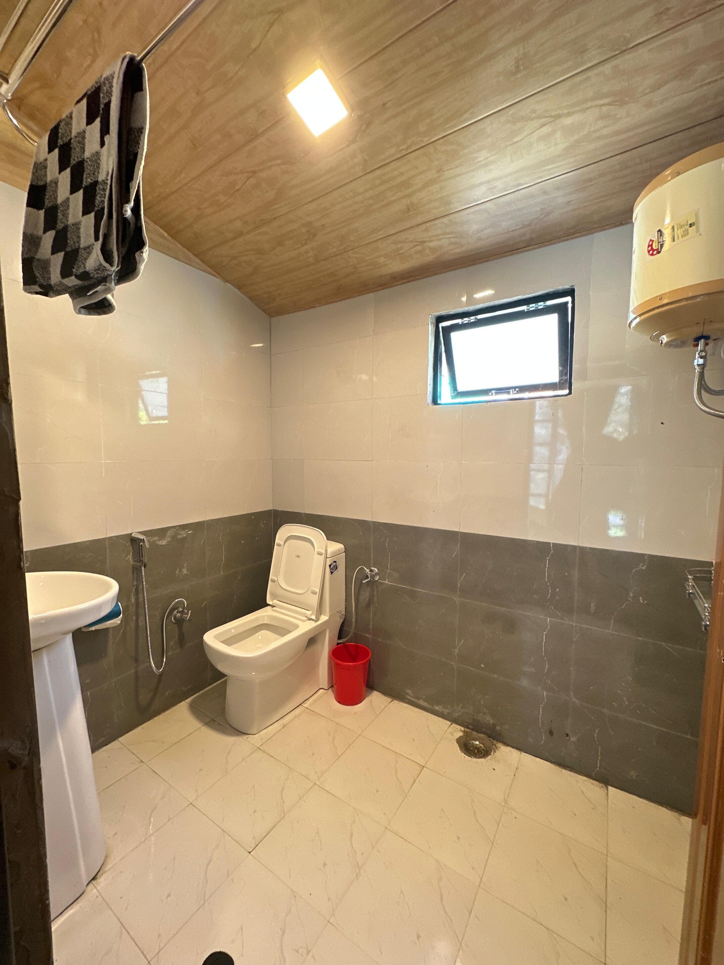 A bathroom with a toilet, sink, and shower.