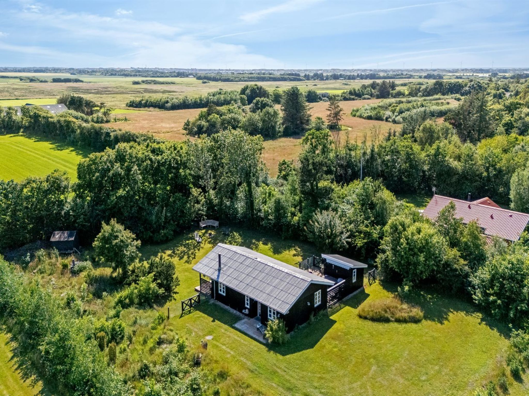 An aerial view of a rural property with a large house surrounded by fields and trees.