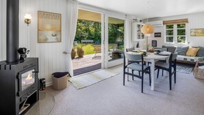 Un salon chaleureux avec une cheminée, un coin repas et un canapé.