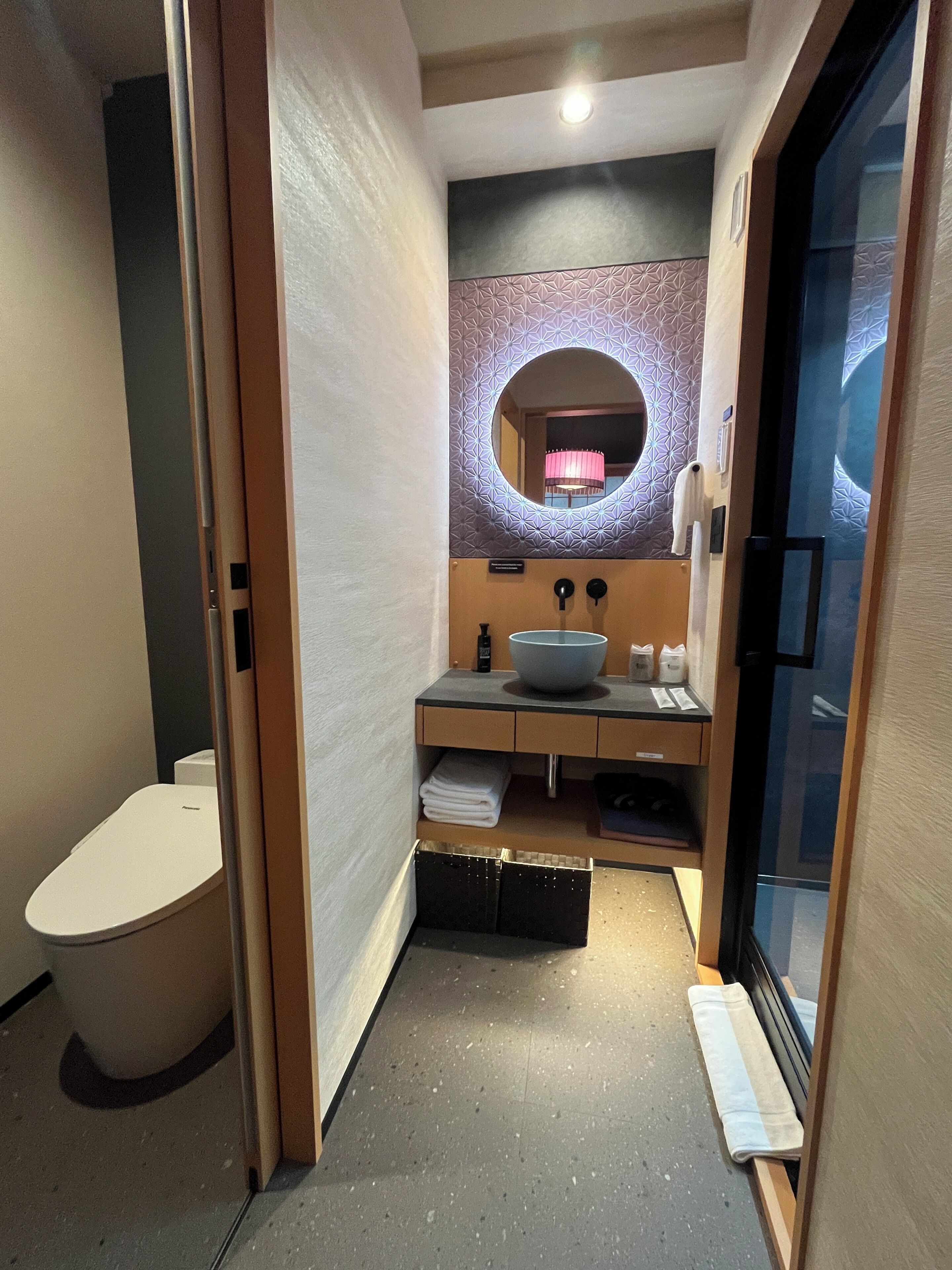A compact bathroom with a toilet, sink, and a mirror.