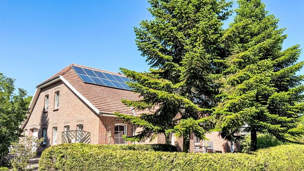 Un edificio de ladrillo con techo inclinado y paneles solares.