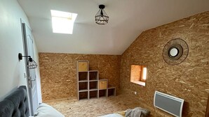 A bedroom with a bed, a wardrobe, a built-in shelf unit, and a ceiling light fixture. - Armand's House (Yssingeaux)