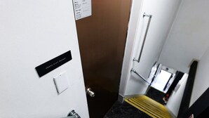 A hotel hallway with a door, a handrail, a marble floor, and a sign on the wall. - XS01 XROSS STAY Namba1 (大阪市)