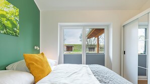 A bedroom with a bed, a window, and a view of the outdoors. - Vacation home "Huus Mullewap" in Kating for up to 4 people (Kating)