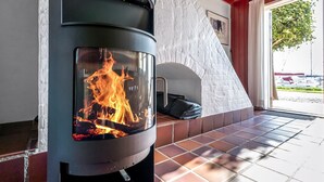 A wood-burning stove with a glass front, a stone wall, and a tiled floor. - "Ulvi" - 15m from the sea by Interhome (Ebeltoft)