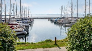 A marina with multiple boats docked, calm water, and a clear view of the distant shoreline. - "Ulvi" - 15m from the sea by Interhome (Ebeltoft)
