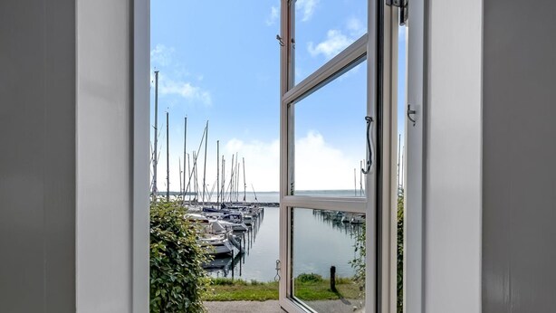 A view through a glass door to a marina with boats docked. - "Ulvi" - 15m from the sea by Interhome (Ebeltoft)