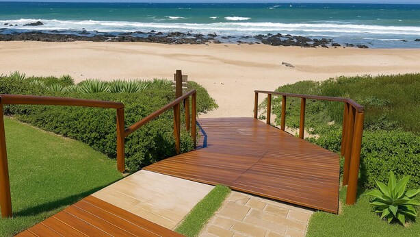 Una escalera de madera que lleva a una playa con vistas al océano.