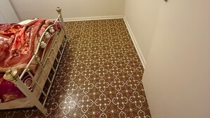 A small room with a bed, patterned floor, and a door with a handle. - One room,$190+bills,Single Girl,3bed room set,Indian ofamily living, (Norwood)
