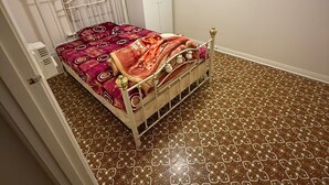 A bedroom with a bed, a wardrobe, and patterned flooring. - One room,$190+bills,Single Girl,3bed room set,Indian ofamily living, (Norwood)