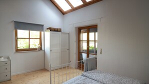 A bedroom with a bed, a wardrobe, a window, and a skylight.
