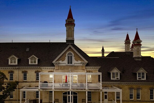 A historic building with a central tower, multiple windows, and a balcony.