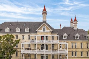A historic building with a central tower, multiple chimneys, and a balcony.