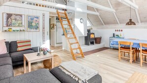A spacious loft with a high ceiling, a wooden staircase, a kitchen area, and a cozy seating area with a sofa and a table. - "Frodde" - 200m from the sea by Interhome (Sydals)