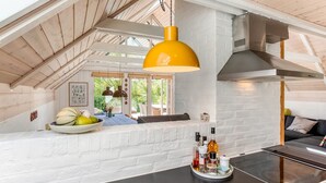 A modern kitchen with a white brick backsplash, a black countertop, and a yellow pendant light. - "Frodde" - 200m from the sea by Interhome (Sydals)