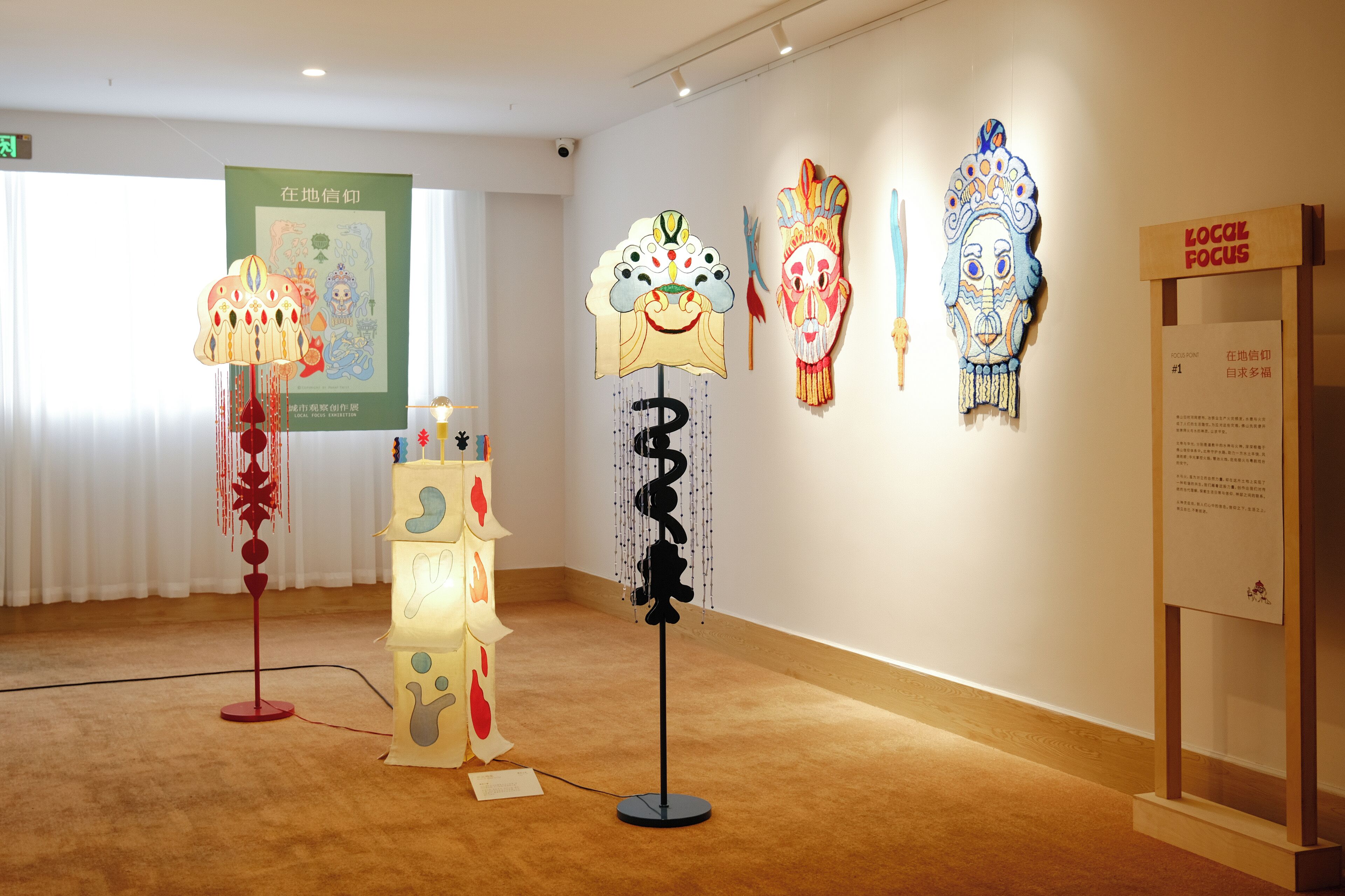 An art gallery with various sculptures and a poster on the wall.