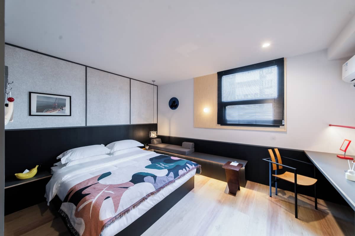 Une chambre à coucher moderne avec un grand lit, un bureau et une chaise.