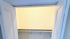 A small, enclosed closet with a wooden floor and a light-colored wall. - Renovated 2 Bedroom Great Central Location!  New Property, Seasoned Superhost (Durham)