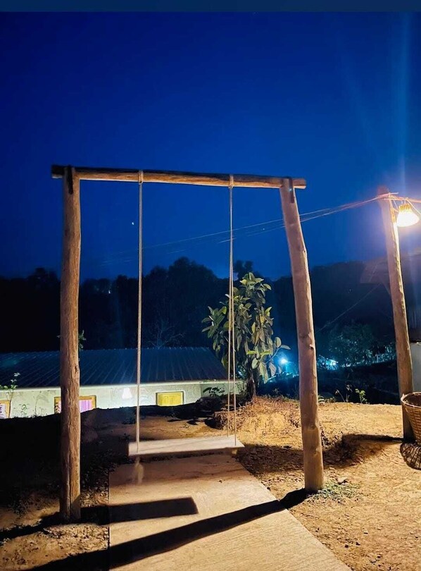 A wooden swing set in a rural setting at night. - Giri Raj Resort Bandarban (Bandarban)