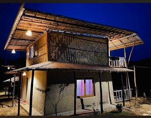 A two-story building with a thatched roof and a balcony. - Giri Raj Resort Bandarban (Bandarban)
