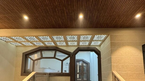 A staircase with a wooden ceiling and decorative panels, leading to an interior space. - Velora Inn  (Varanasi)