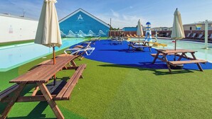 A poolside area with lounge chairs, umbrellas, and picnic tables. - 3 bedroom accommodation in Hayling Island (Hayling Island)