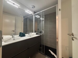 Chuveiro, banheira de hidromassagem, secador de cabelo, toalhas de banho