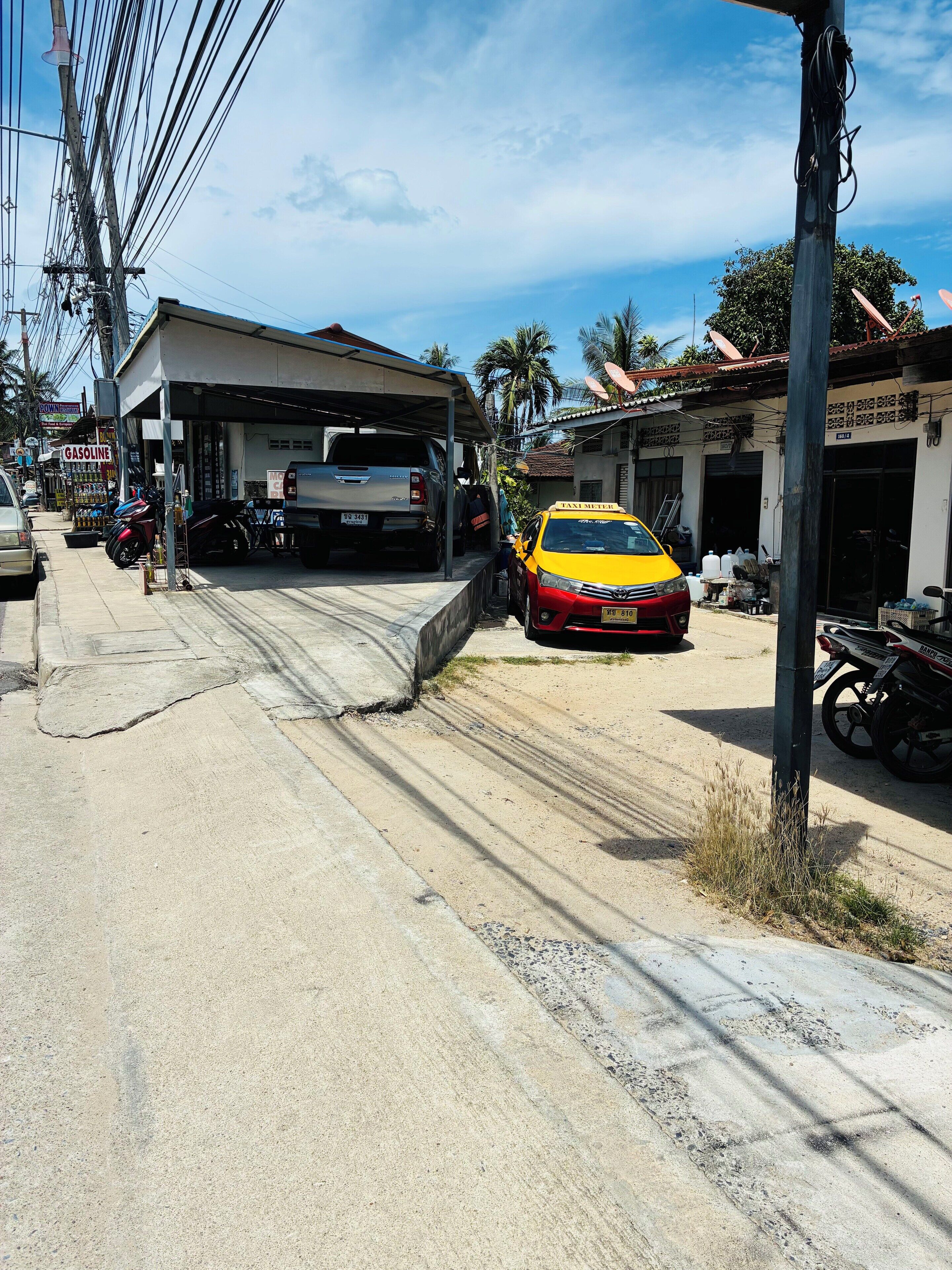 A gas station with a car and a motorcycle parked in front.