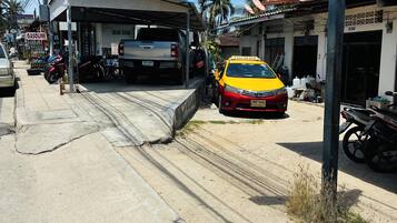 A gas station with a car and a motorcycle parked in front.