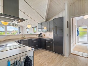 Een koelkast, een vaatwasser, kookgerei, borden en bestek