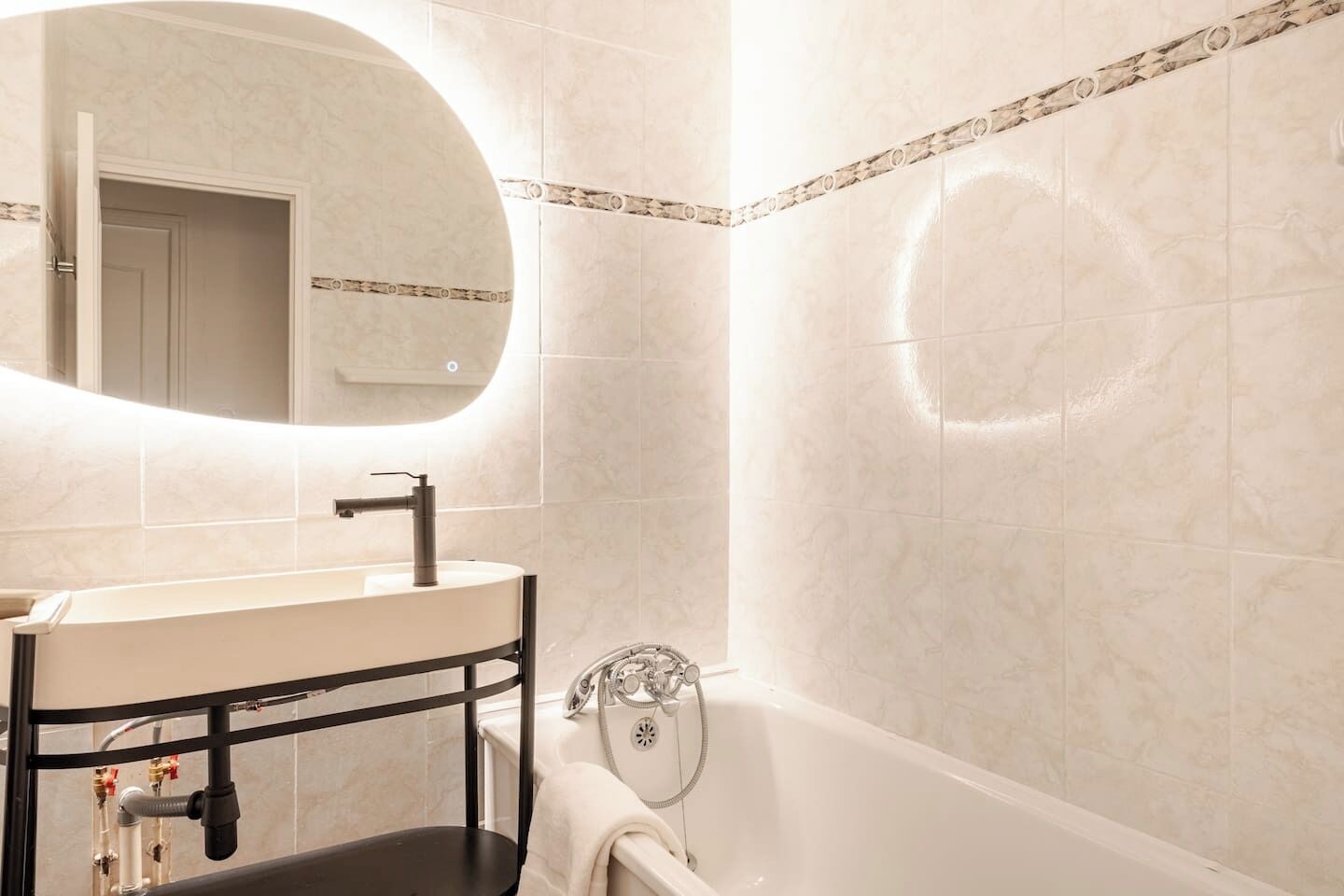 Un baño con lavamanos, espejo y bañera.