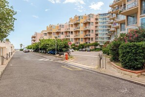 A multi-story residential building with balconies, a gated entrance, and a clear sky. - L'écrin du Lydia - T3 with Clim and Lydia view (Le Barcarès)