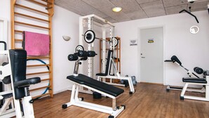 A gym with various exercise equipment, including benches and weight machines.
