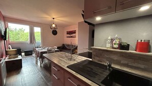 Une cuisine moderne dotée d’un grand îlot central, d’un évier et d’un coin repas avec une table et des chaises.