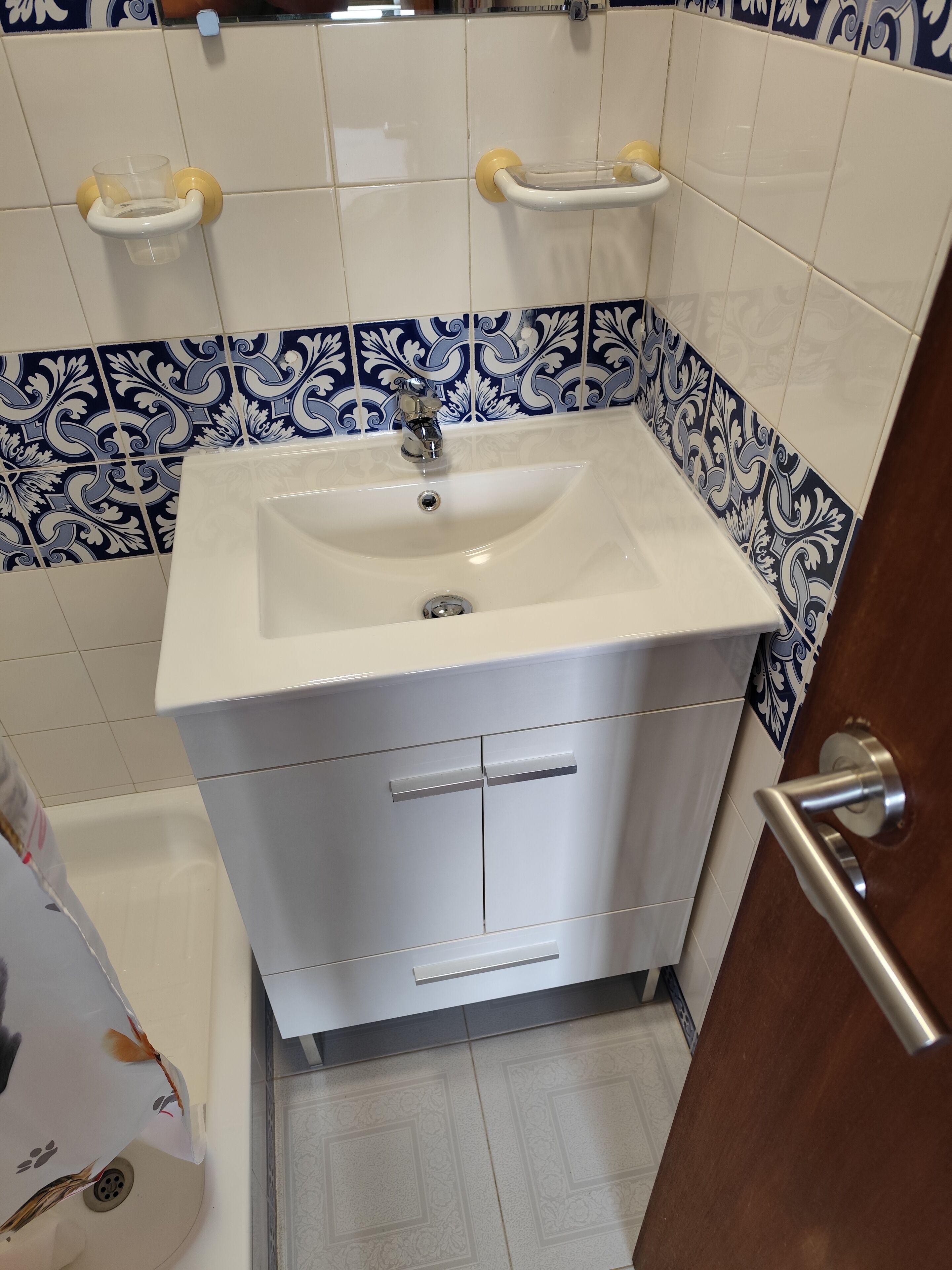 A bathroom with a white sink, a mirror, and a door.
