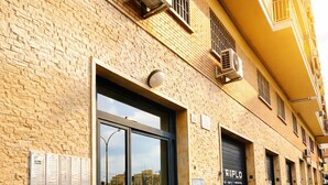 A building with a brick facade, large glass windows, and air conditioning units. - Apartment Mari&Lucio-Metro Basilica S.Paolo, 4 stops to Colosseum, 15min Termini (Roma)