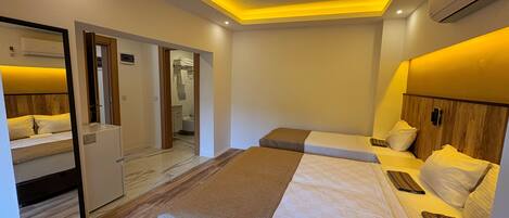 A modern hotel room with a large bed, a smaller bed, and a walk-in closet.