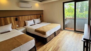 A hotel room with two beds, a wooden headboard, a large window, and an air conditioning unit.
