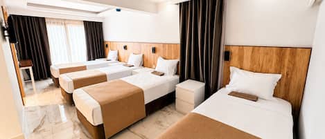 A hotel room with three beds, a wooden headboard, a marble floor, and a television on the left.