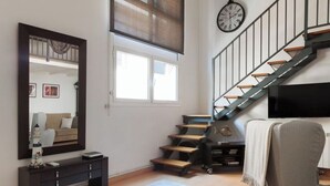 A modern living room with a staircase, a large mirror, a flat-screen TV, and a sofa. - ¡Hola! :) ¿cómo estás? Ideal Acomodis Duplex apartment, 15 min from Las Ramblas! (Barcelona)