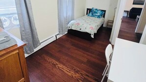 Un dormitorio con cama, escritorio y silla.