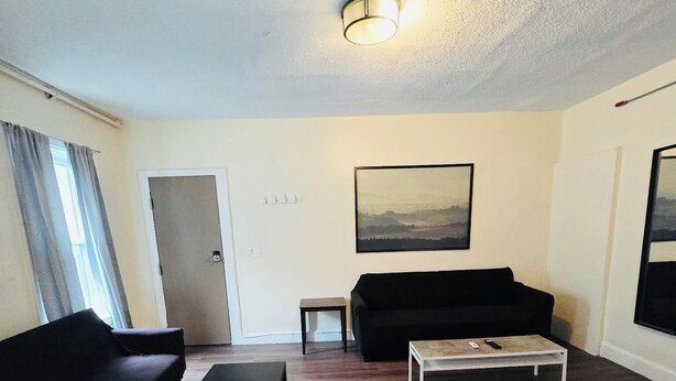 Una sala de estar con un sofá, una mesa de centro y un cuadro en la pared.
