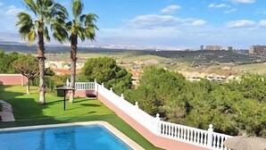 A pool area with a view of a hilly landscape and distant buildings. - Alicante Vacation Home (Gran Alacant)