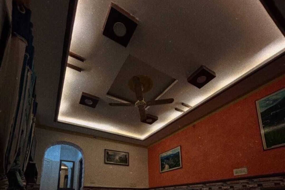 A room with a ceiling fan, a bed, a sofa, and a fireplace.