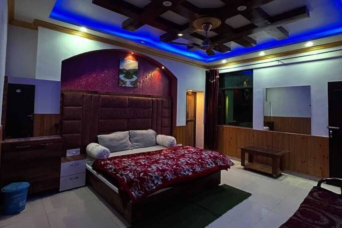 A bedroom with a bed, a desk, and a chair. There is a window and a door.