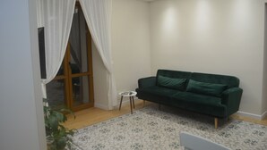 A modern living room with a green sofa, a small side table, and a patterned rug. - The Prince's Palace, a historic mansion (Abruzzo)
