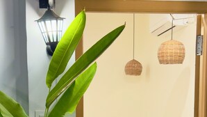 Ein Schlafzimmer mit einem hölzernen Bett, einem kleinen Holztisch und einer Zimmerpflanze.