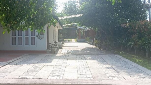 A paved pathway leading to a building with a covered entrance, surrounded by greenery. - The Garden Resort Airport Katunayaka (Katunayake)